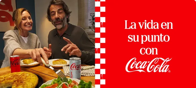 Página oficial de Coca-Cola España con el mensaje «La vida en su punto con Coca-Cola» y dos personas comiendo tortilla con minilatas.