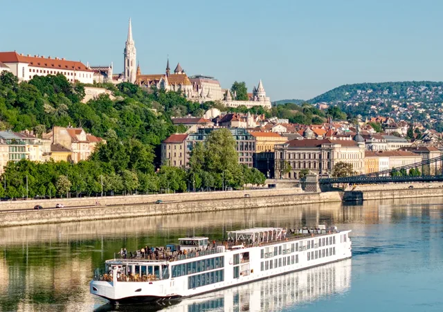 A Viking river ship sailing on the Danube in front of Budapest, shown for the Romantic Danube itinerary of the MASTERPIECE sweepstakes.